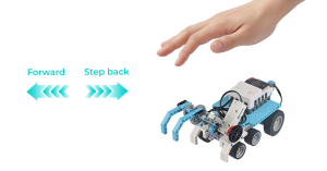 Student using hand gestures to control an ELECFREAKS micro:bit Nezha Pro AI Mechanical Power Kit robot car, demonstrating gesture recognition and interactive STEM learning with AI and mechanical power.