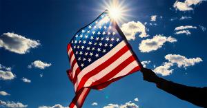 U.S. flag on the Sun background, symbolizing security, opportunity and stability. Invitation to join Bayat Group’s seminar in Dubai on the EB-5 Visa and VOCO Times Square project.