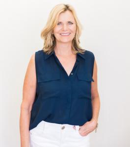 Renee Ascencio, CEO of Natural Healing Center, smiling in a professional portrait wearing a navy sleeveless blouse and white pants against a light background.