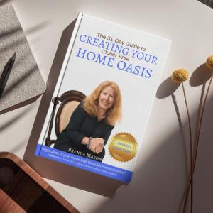 A copy of Brenda Mason Parmelee’s book “The 31-Day Guide to Create Your Clutter-Free Home Oasis” resting on a desktop, representing her Downsizing31™ Method and message of peaceful, clutter-free living.