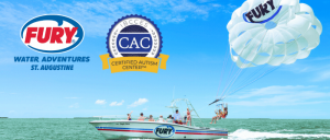 A Fury Water Adventures boat in St. Augustine, with people parasailing under a blue sky and logos for their services as a certified autism center.