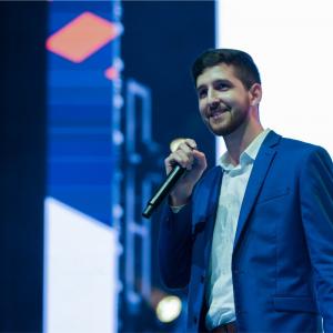 Marc A. Maceira, holds a microphone while giving a presentation at an innovation conference.