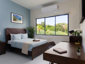 patient bedroom with a bed, desk and large window