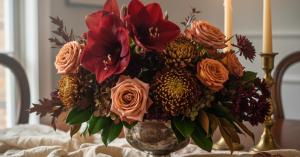 Vintage Prep Thanksgiving centerpiece with deep crimson Amaryllis, dusty roses, and heirloom mums in silver vessel