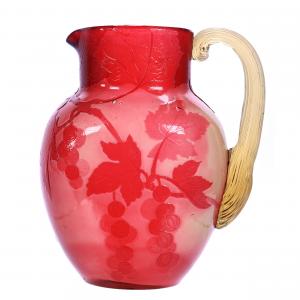 French cameo art glass water pitcher signed Galle, 7 ½ inches tall, fire polished white with cranberry vintage décor overly and a yellow applied ribbed handle. Estimate: $1,500-$3,000.