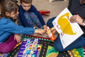 Two children are using PECS during a reading lesson to enhance communication