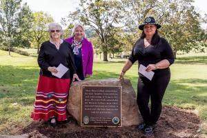 Chief Shields, President Hutson, and Assistant Chief Parrish gather around the land acknowledgment plaque.