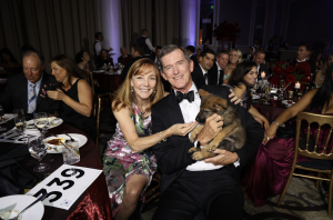 Mike Meyer & wife Elaine celebrate winning the beloved annual “Puppy Love” auction item, taking home an adorable 8-week-old German Shepherd puppy pictured here in the ballroom with the puppy