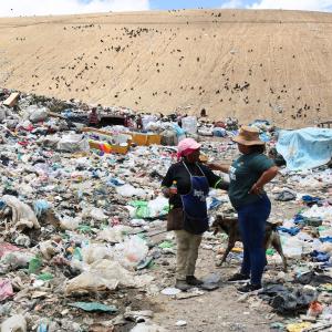 An International Samaritan team member talks to a woman working at a city garbage dump in Honduras.