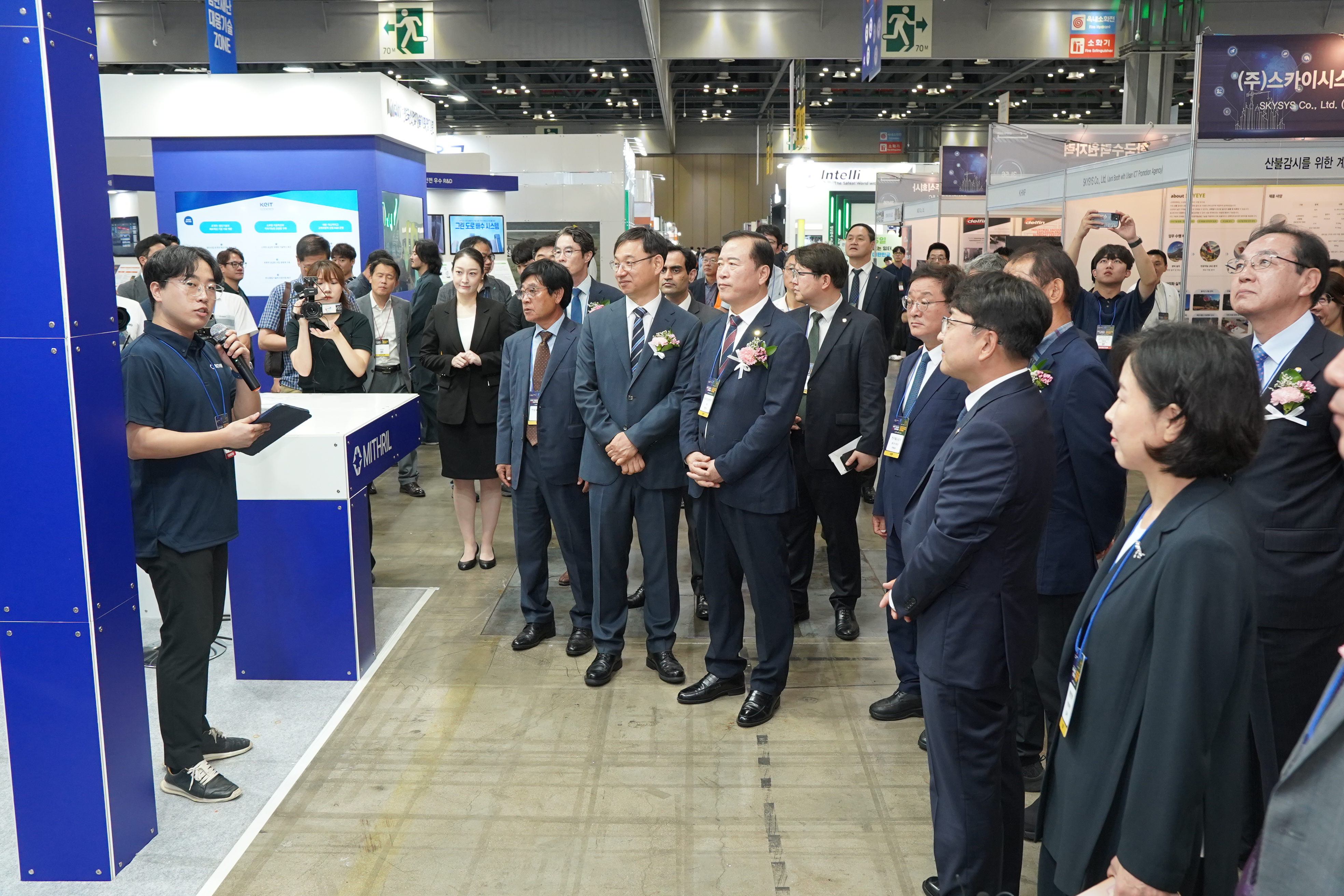 A group of government officials and other invited guests listening to a presentation from Mithril.