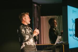 Shane Krider speaking on stage during Prosperity Of Life’s 8-Day Sovereignty Live™ virtual event, teaching mindset, wealth creation, and personal sovereignty.
