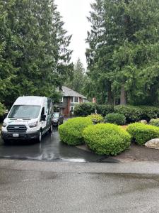 Melby Electric service van parked in a residential area with green bushes and trees