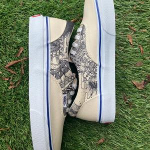 Beige VANS sneakers featuring hand-drawn black ink patterns of plants and geometric motifs. A wearable artwork by artist Initial5, themed around life and nature.