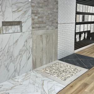 Interior of Tile Factory Direct Gainesville showroom with tile wall and floor displays.