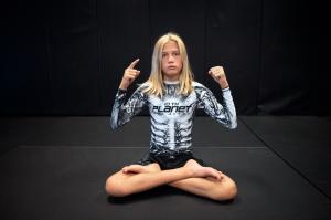 Combat Cruz Hooper displays his 10th Planet hand sign while sitting lotus style