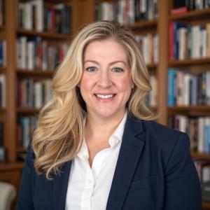 Elizabeth Javor, Founder of The Book Marketing Source. Standing in front of a book shelf.