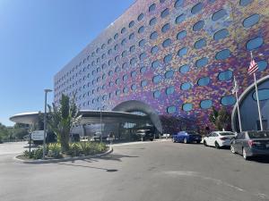 An exterior photo of the Stella Nova Resort at Universal Orlando. N-RG Cladding helped wrap the building in 140,000 color-shifting tiles, creating a stunning visual entrance to the building.
