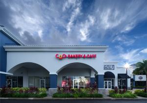 Exterior view of CAO Bakery & Café in Winter Springs, Florida, featuring the Cuban bakery’s signature red signage and welcoming storefront where customers enjoy traditional pastries, sandwiches, and cafecito.