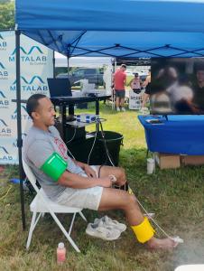 An athlete smiles while receiving ANS Pulse Wave Analysis testing at the MetaLab by Confidia booth during Factory Summer Slam in Southington, Connecticut.