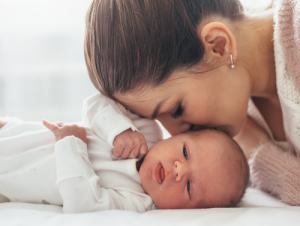 Mother kissing newborn baby