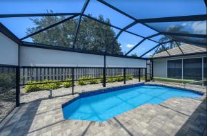 Retractable screen system enclosing a backyard pool, designed to block sun, reduce heat, and keep out bugs.