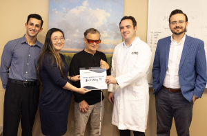 Neal Bench, CRF President, awarding Alice Zhang, MD the 2025 Randy Wheelock Award. They are posing with three men from the UNC Ophthalmology team.