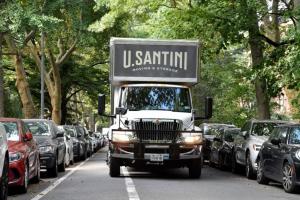 U.Santini Moving & Storage truck on a tree-lined street in Park Slope, Brooklyn, surrounded by parked cars during a residential move.