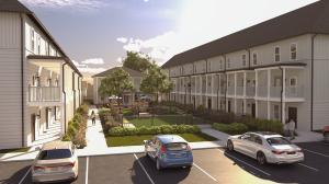 Outdoor amenities area at Mitchell Yards student housing in Fayetteville, Arkansas, showing landscaped courtyard, seating areas, and modern townhomes designed for safety and community.