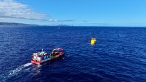 A cylindrical floating structure being towed from the port of Las Palmas to PLOCAN