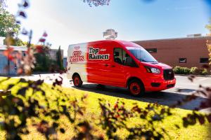 Nissin Foods Ramen Roadshow vehicle with Top Ramen and Cup Noodles logos, shown in a parking lot