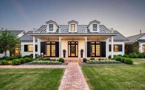 The Southern-inspired architectural façade of the $6.75 million modern luxury estate in Arcadia, Phoenix, featuring a covered porch, gas lanterns, and unobstructed Camelback Mountain views.