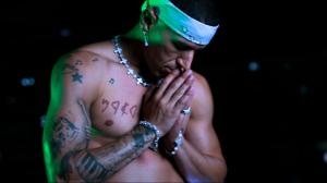 Klypso praying in a reflective scene from the “Stray Cat” music video, symbolizing emotion, faith, and the search for light after loss.