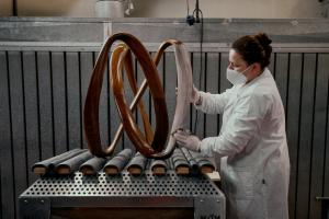 An artisan at Porada hand-sands a solid wood form — a quiet act of precision that defines the soul of Italian craftsmanship.