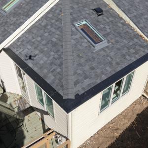 Aerial photo of a gray asphalt shingle roof with a skylight and seamless black gutters on a Toledo, Ohio home by All Exterior Solutions.