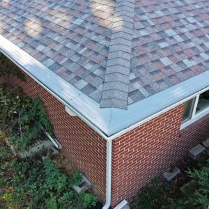 Shingle roof with seamless white gutters and guards on Toledo brick home by All Exterior Solutions.