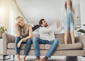 Stressed couple sitting on couch experiencing mental health challenges, illustrating the need for accessible ADHD and psychiatric care
