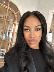 Quanda S. Francis, Black woman founder and CEO of WombWatchAI, smiling confidently in professional black attire against elegant home office