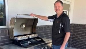Staff Zone team member grilling food on a large outdoor gas grill during a branch Thanksgiving celebration for construction workers as part of the company’s annual tradition.