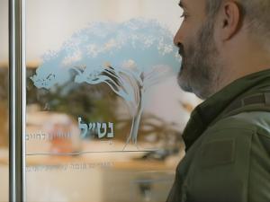 Person walking to therapy session and pulling a glass door.