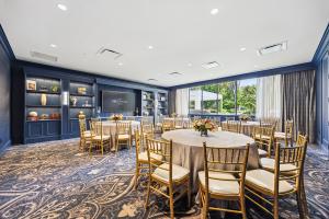 The Teak Room features wooded views and stately millwork, carpets, Shantung wallcoverings, and custom cabinetry in stately hues of deep blue and gold.