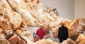 Two people viewing a large-scale paper installation