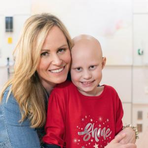 Bridget as a young girl and Jaime smiling. Bridget is bald from chemotherapy treatments.