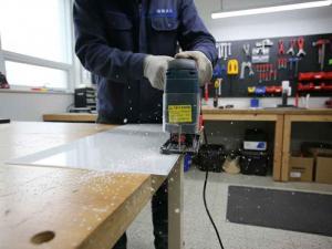 Acrylic sheet being cut with a jig saw.