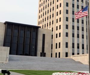 Exterior of a government building next to an American Flag.