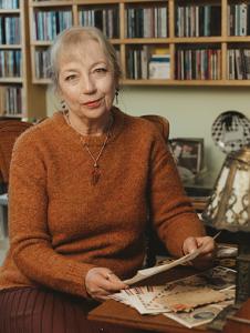author portrait of Laura J. Cameron sitting at antique desk holding her father's letter