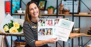 A happy teacher receives a GroupTogether card and gift from the whole class.