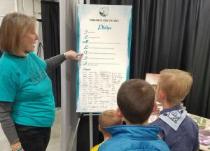 Volunteer from the Church of Scientology Denver shows the Drug-Free Pledge to youngsters attending the expo.