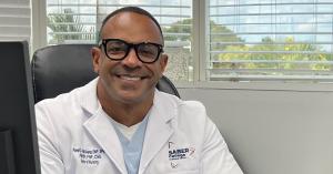 Dr Pavel Pugh, SABER College Nursing Program Director smiles at the camera from his office.