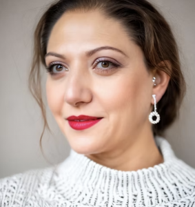 Professional headshot of Victoriya Reich, LISW-S, Co-Founder of TheraVault, wearing a white sweater and statement earrings.