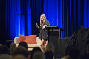 Rachel Krider speaking on stage at a Prosperity Of Life training event in 2016.